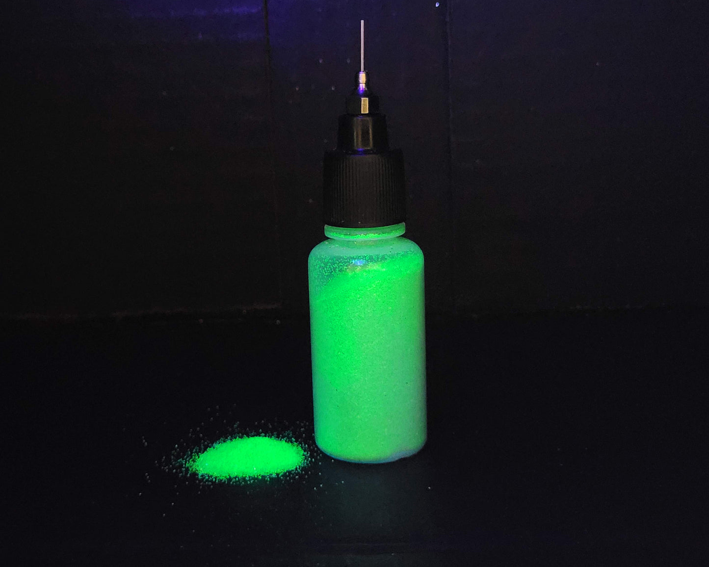 bottle of lime green uv glitter glowing under uv light