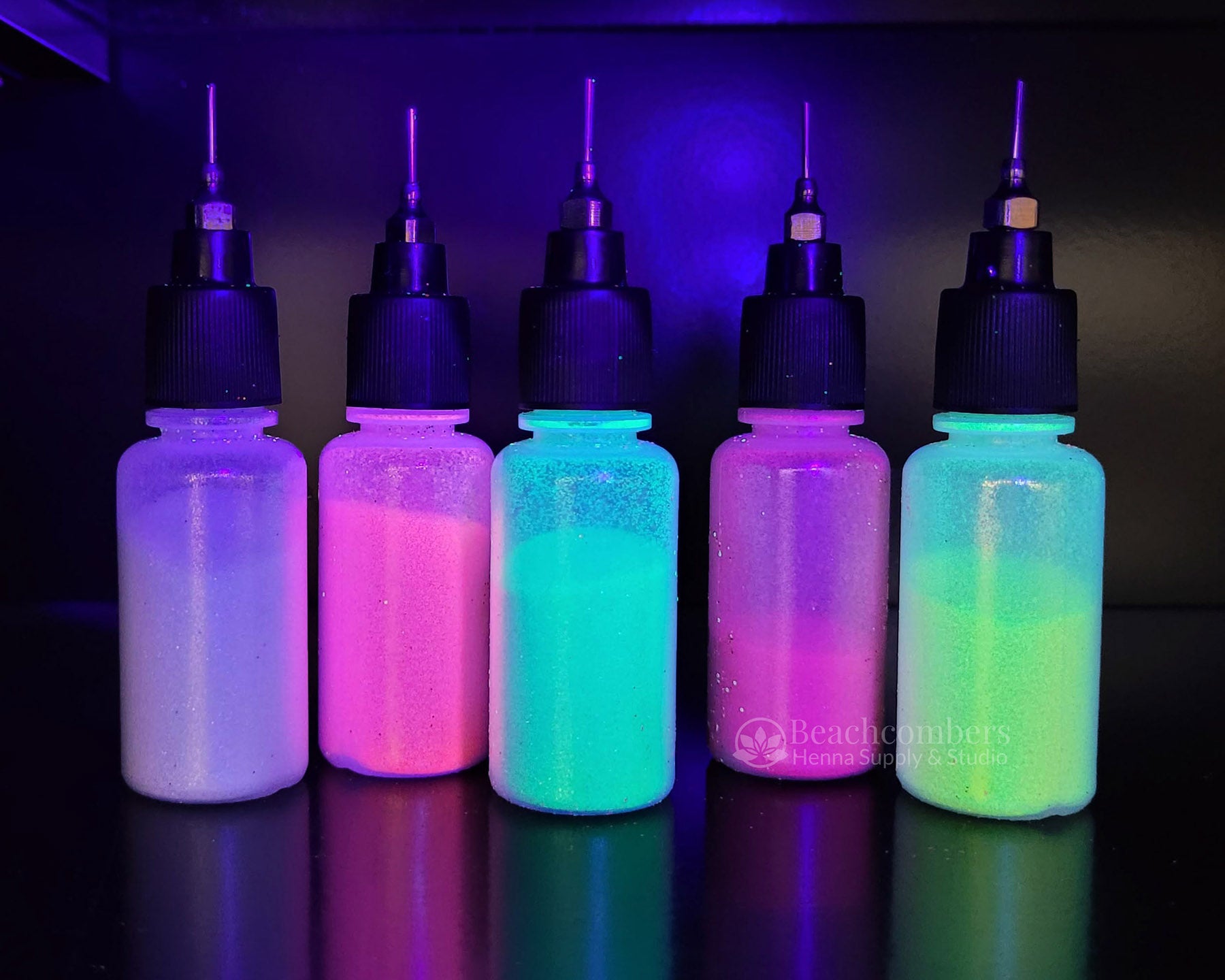 5 bottles of glowing glitter under UV light