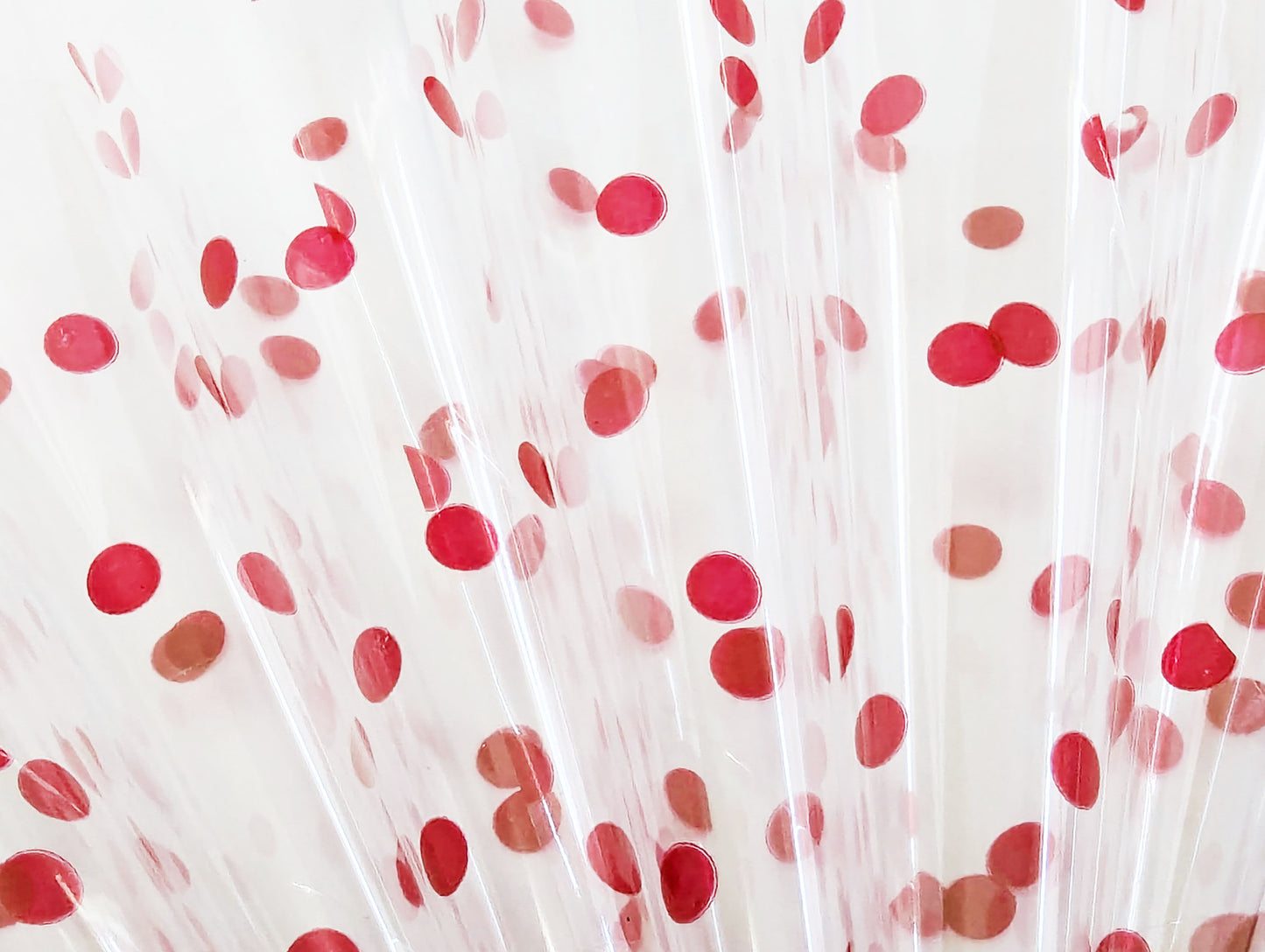 Close up of translucent cello flats with red dots rolled into cones