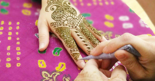 Close up of a henna cone applying henna on top of a hand