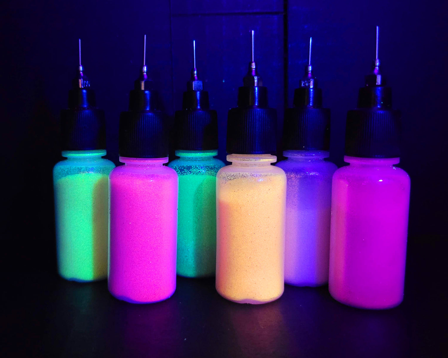 6 bottles of henna body glitter under UV light