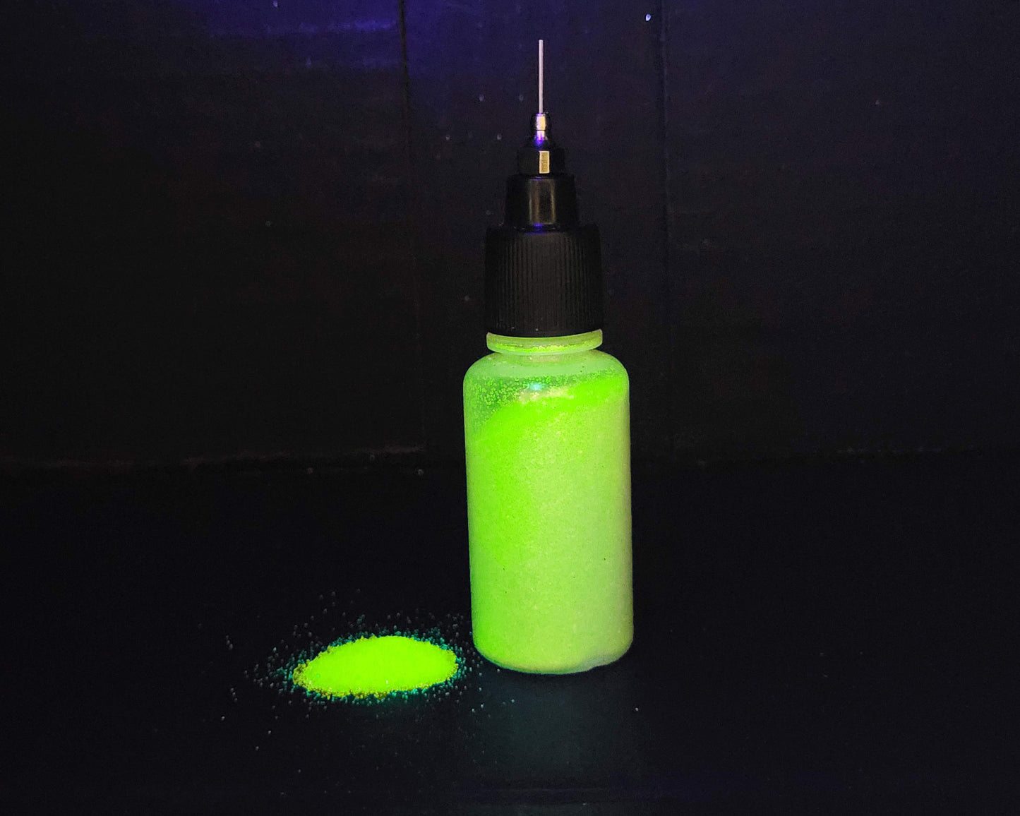 Bottle of neon yellow body glitter glowing in UV light