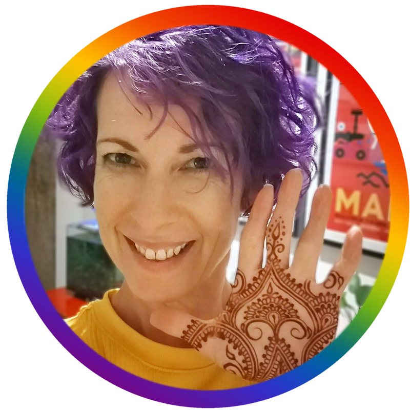 picture of Jody's face with a hennaed palm. A rainbow circle is around the picture.