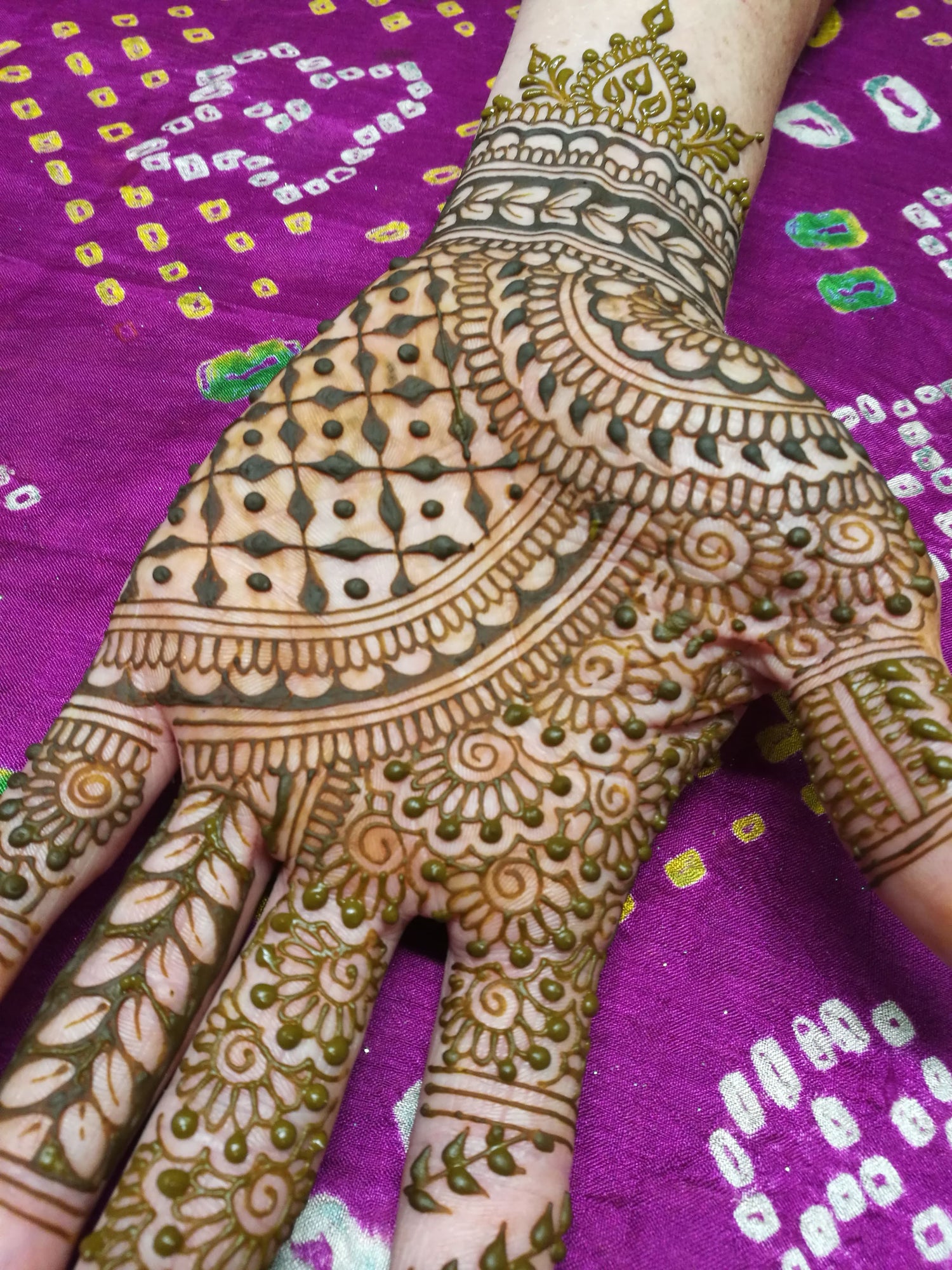 Palm side of a an intricate Indian wedding style henna with a seed of life grid.