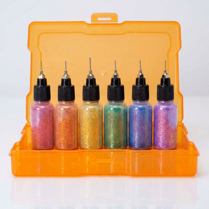 A high-resolution studio shot of the Rainbow Glitter Gift Box, showcasing its vibrant rainbow pride colors—red, copper/orange, gold/yellow, green, blue, and purple—illuminated by softbox lighting that enhances the glitter's reflective properties. The camer