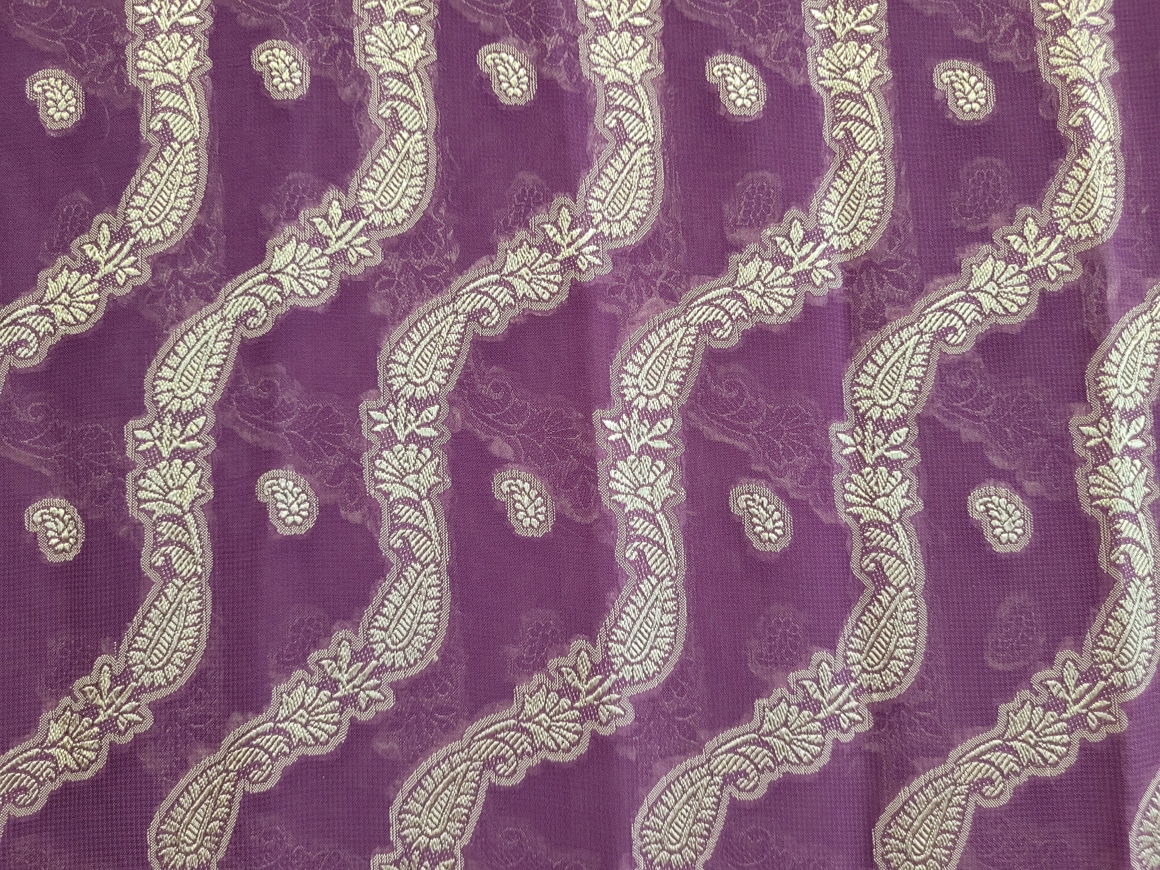 Close up of sari fabric purple with a silver henna-inspired paisley pattern